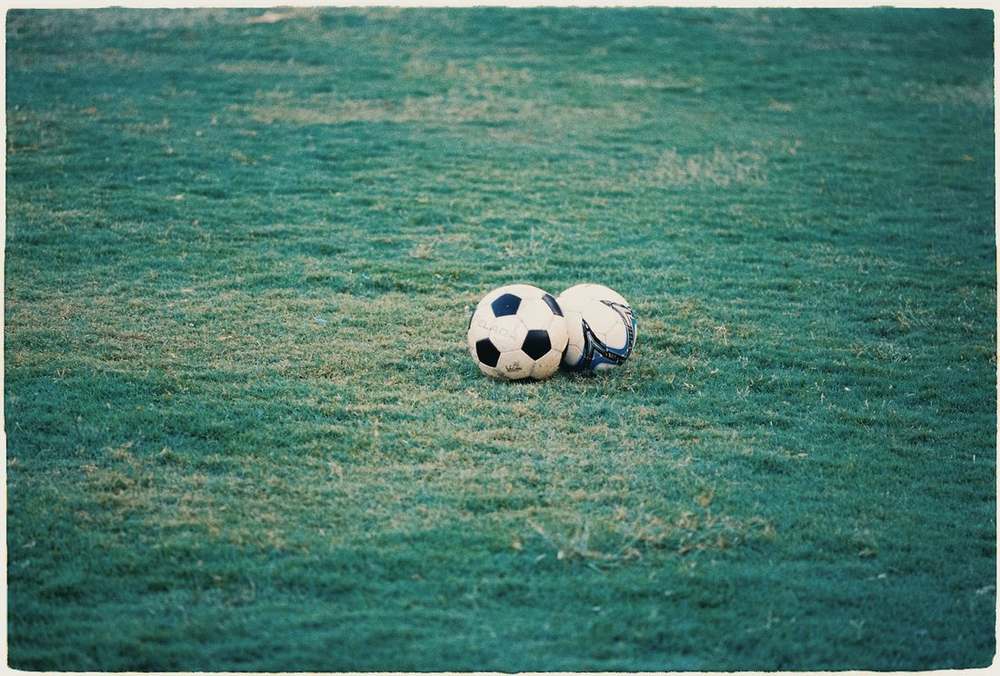 Bola sepak di atas rerumputan lapangan hijau