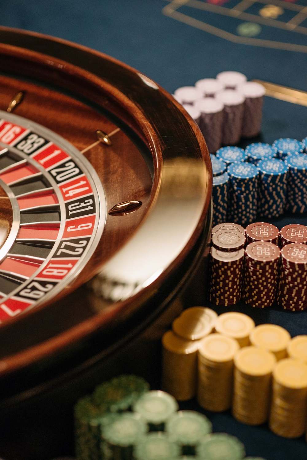 Meja roulet dengan roda dan tumpukan chip kasino